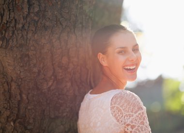genç kadın ağacına yalın gülüyor