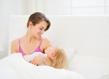 mutlu genç anne holding uyuyan bebek