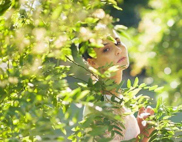 Портрет молодой женщины, скрывающейся в листве — стоковое фото