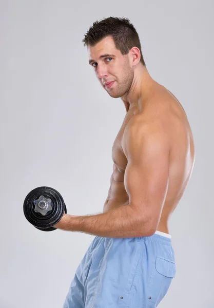 Sterke sport man training biceps met dumbbell — Stockfoto