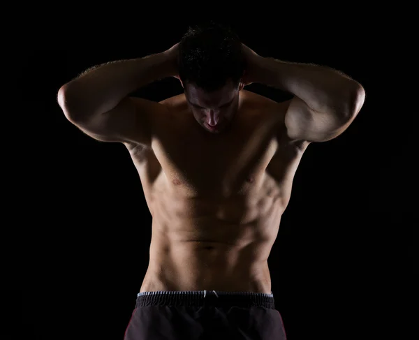 Atleta masculino forte posando no preto — Fotografia de Stock