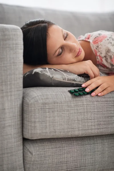 Молодая женщина спит с упаковкой таблеток — стоковое фото
