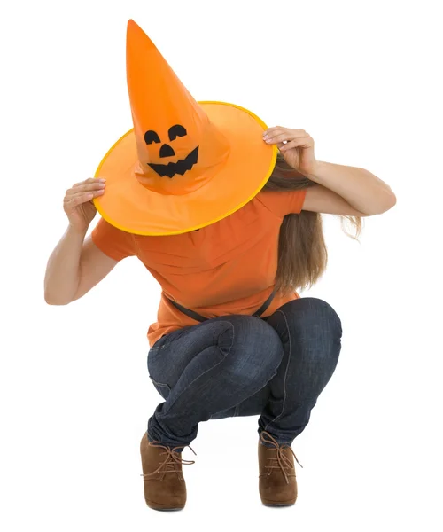 Mulher sentada com chapéu de Halloween puxado sobre a cabeça — Fotografia de Stock