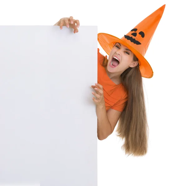 Женщина в шляпе на Хэллоуин с пустым рекламным щитом — стоковое фото