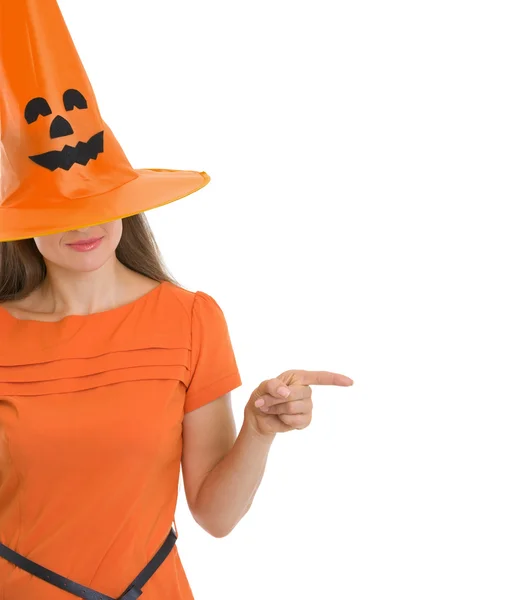 Frau mit Halloween-Hut über Augen, die auf Kopierraum zeigen — Stockfoto