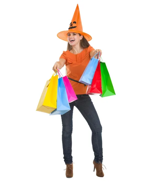 Mujer sonriente en sombrero de Halloween con bolsas de compras —  Fotos de Stock