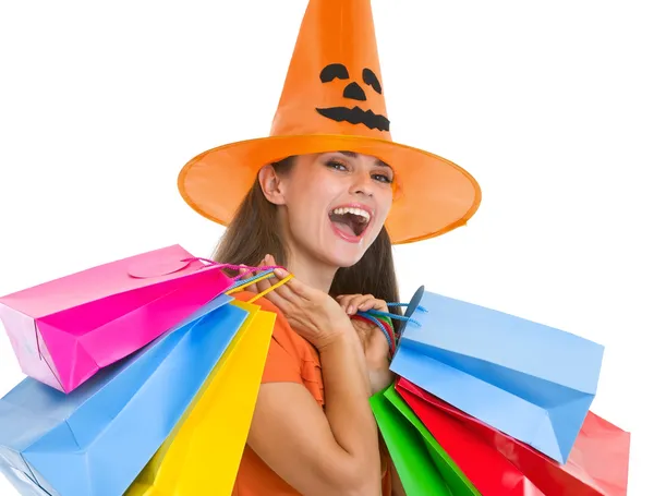 Mujer joven feliz en sombrero de Halloween con bolsas de compras —  Fotos de Stock