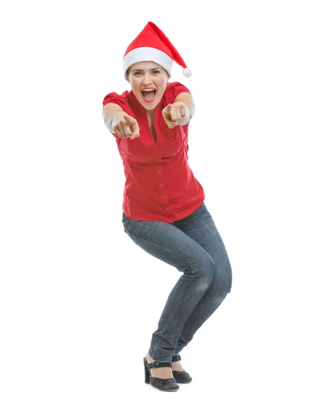 Fröhliche junge Frau mit Weihnachtsmütze, die in die Kamera zeigt — Stockfoto