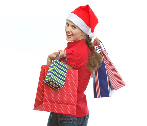 Giovane donna in cappello di Natale con borse della spesa guardando fuori — Foto Stock
