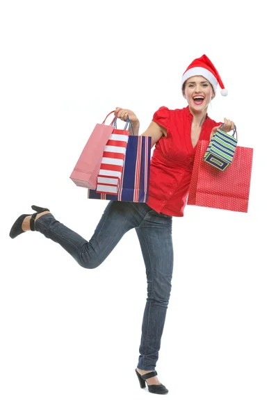 Joven alegre en Santa sombrero sosteniendo bolsas de compras — Foto de Stock