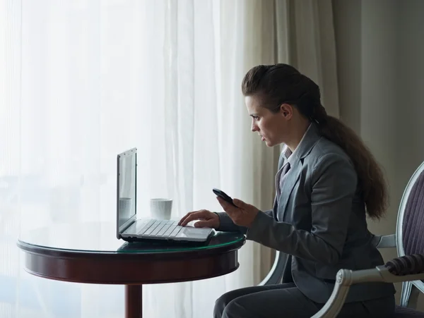 Femme d'affaires travaillant sur ordinateur portable dans la chambre d'hôtel — Photo