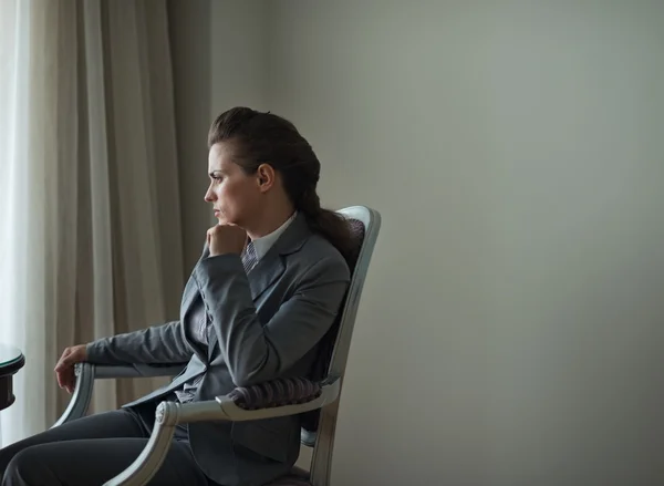 Thoughtful business woman sitting in hotel room — Stock Photo, Image