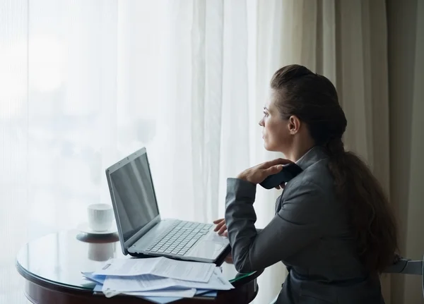 Mujer de negocios reflexiva que trabaja en la habitación de hotel — Foto de Stock