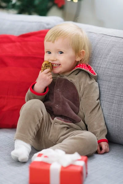 Feliz bebé en traje de ciervo con regalo de Navidad caja comer galleta —  Fotos de Stock