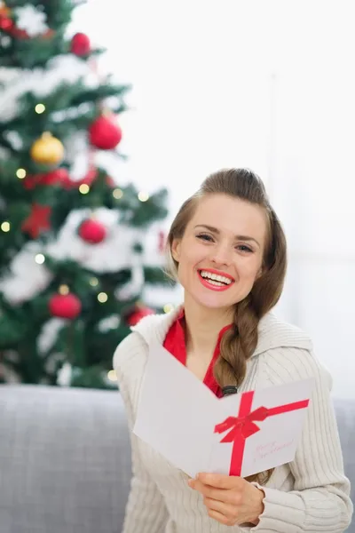 Jeune femme souriante avec carte postale de Noël — Photo