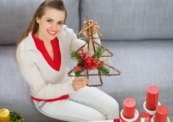 Sorrindo jovem mulher mostrando decorações de Natal — Fotografia de Stock