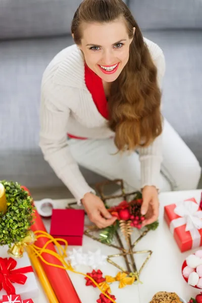 Lachende jonge vrouw kerstversiering maken — Stockfoto