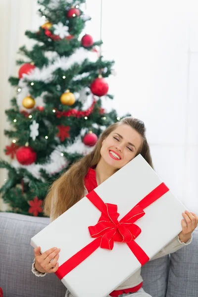 Glückliche junge Frau umarmt große Weihnachtsgeschenkschachtel — Stockfoto