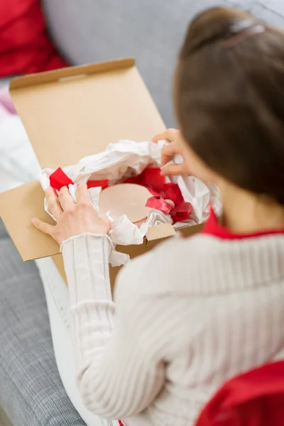 Frau packt Paket mit Weihnachtsgeschenk aus — Stockfoto