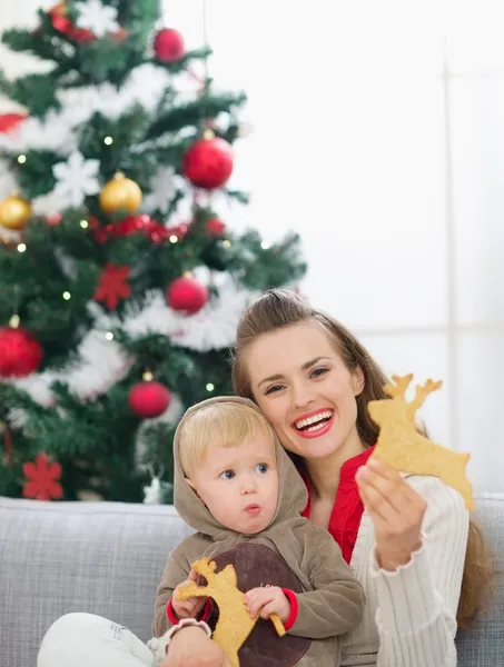 Mamma e bambino mangiare biscotti a forma di cervo di Natale — Foto Stock