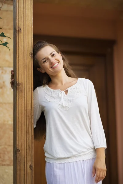 Lachende vrouw permanent op deur — Stockfoto