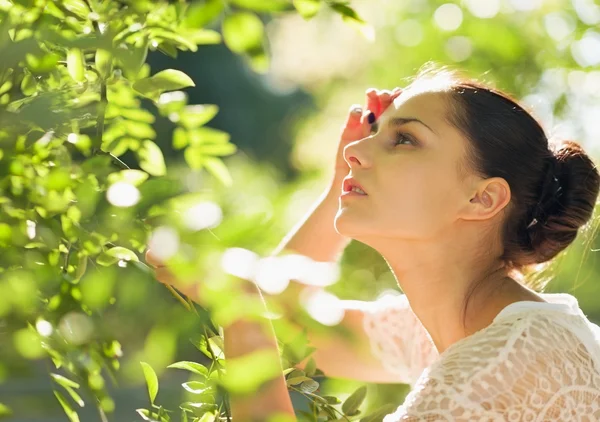 Portrait of young woman in foliage looking on copy space Stock Image