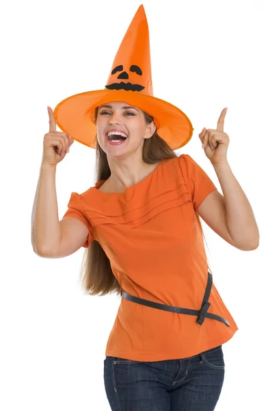 Happy young woman in Halloween hat pointing up Royalty Free Stock Images