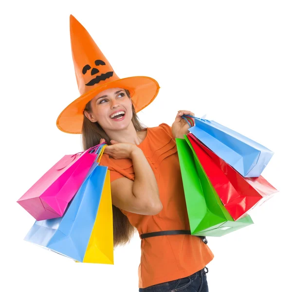 Happy woman in Halloween hat with shopping bags looking on copy Stock Photo