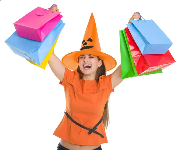 Smiling woman in Halloween hat rising up shopping bags Royalty Free Stock Images