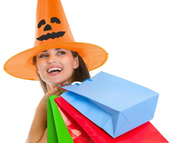 Happy woman in Halloween hat with shopping bags looking on copy Royalty Free Stock Images