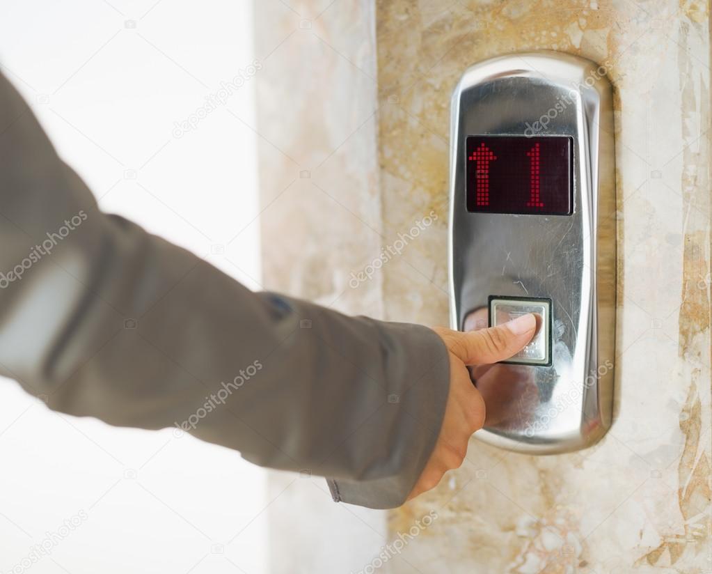 Closeup on business woman hand pushing elevator button