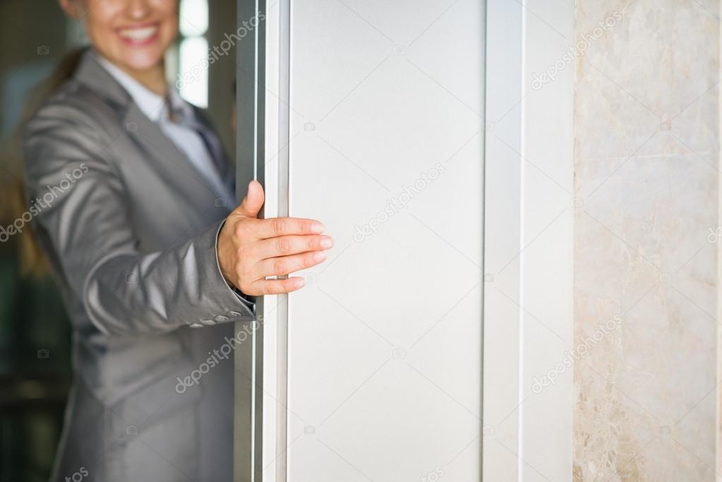 Closeup on business woman hand holding elevator door