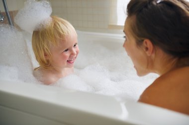 Anne ve bebek banyo ve köpük ile oynama