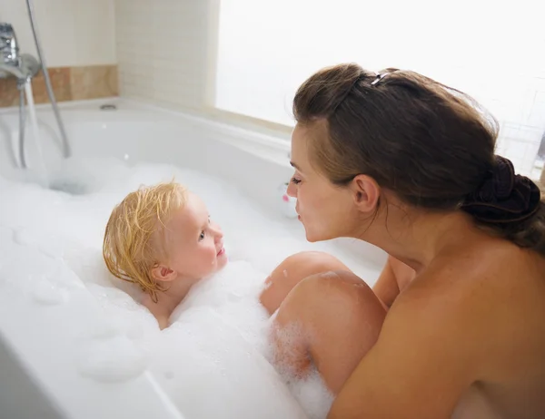 Mamma och baby tvätta i skum fyllda badkar — Stockfoto