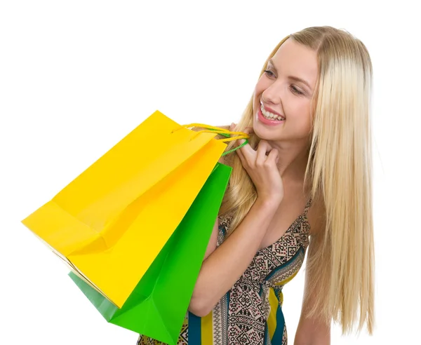 Tizenéves lány mosolyogva a bevásárló szatyrok keres másol hely — Stock Fotó