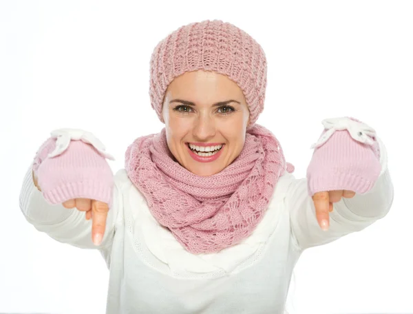 Happy young woman in knit winter clothing pointing down — Stock Photo, Image