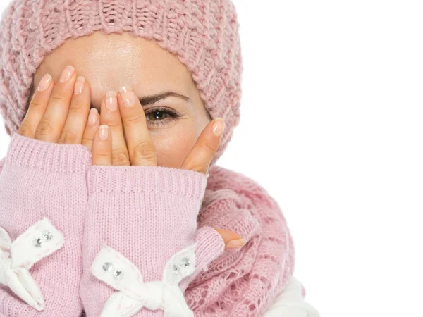 Woman in knit scarf, hat and mittens hiding behind hands — Stock Photo, Image