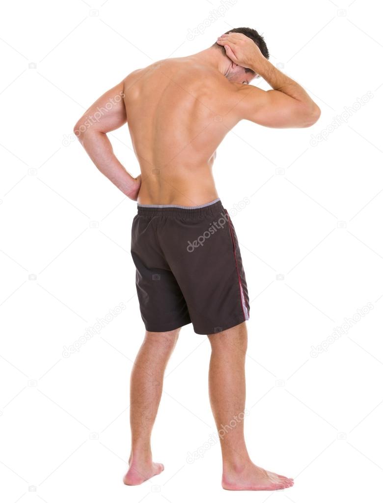 Strong man sports man showing muscles. Rear view