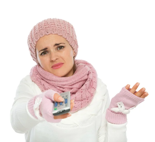 Mulher entediada em roupas de inverno tricô usando TV controle remoto — Fotografia de Stock