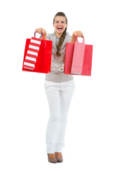 Mulher feliz em suéter com sacos de compras vermelhos — Fotografia de Stock