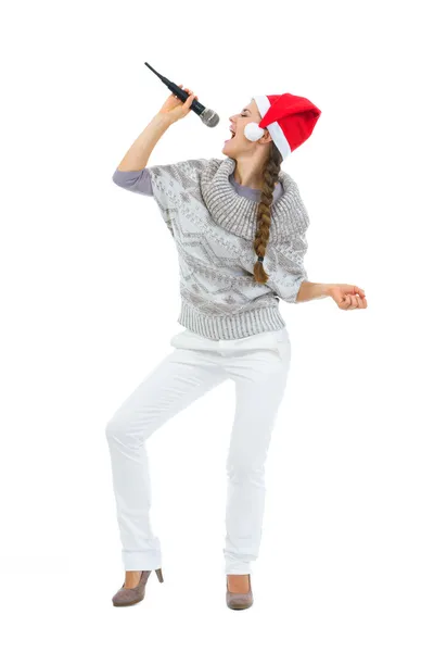 Gelukkige vrouw in santa hat zingen in de microfoon — Stockfoto