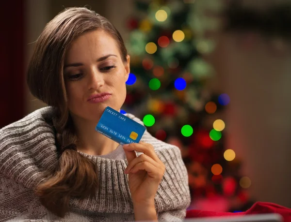 Doordachte vrouw voor kerstboom creditcard bedrijf — Stockfoto