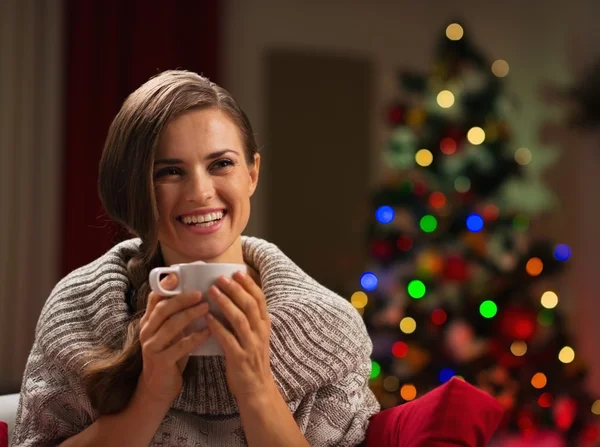 Jovencita sonriente con taza de chocolate caliente delante de Cristo — Foto de Stock