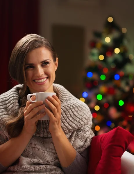 Joyeux jeune femme avec tasse de chocolat chaud devant Noël — Photo