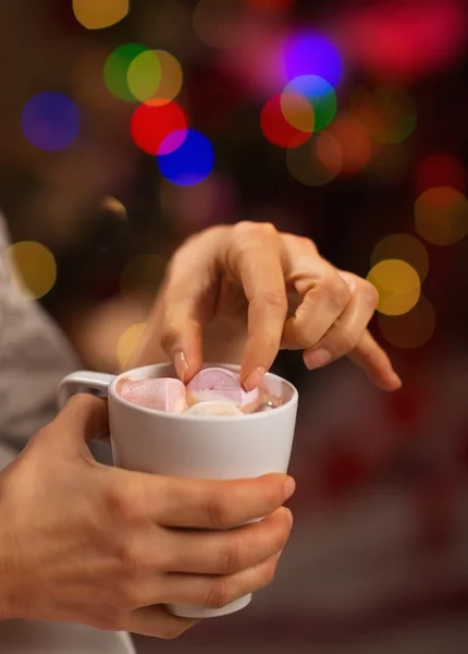 Close-up op hand nemend marshmallow van kopje warme chocolademelk — Stockfoto