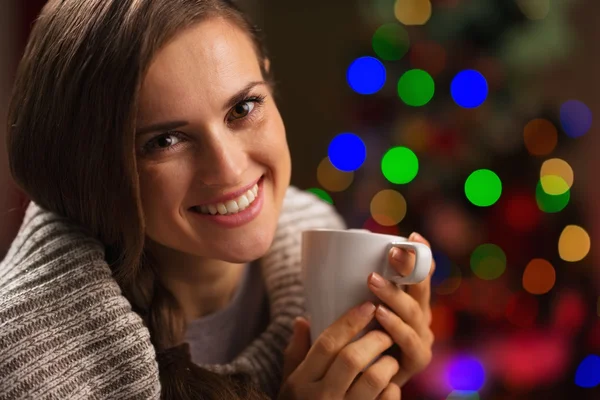 Happy young woman enjoying cup of hot chocolate in front of Chri — Stock Photo, Image