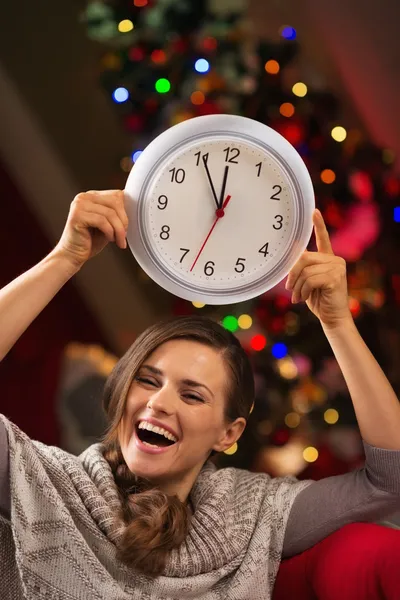 在圣诞树前快活的女人显示时钟 — 图库照片
