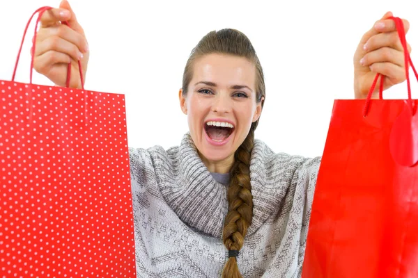 Donna felice in maglione che mostra borse della spesa rosse — Foto Stock