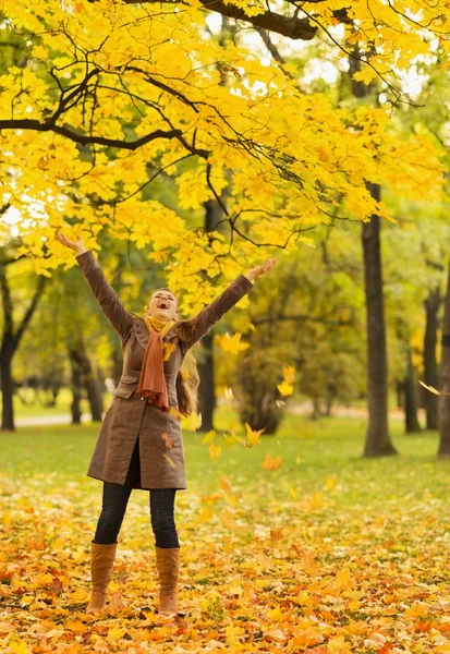 Femme heureuse jetant des feuilles tombées — Photo
