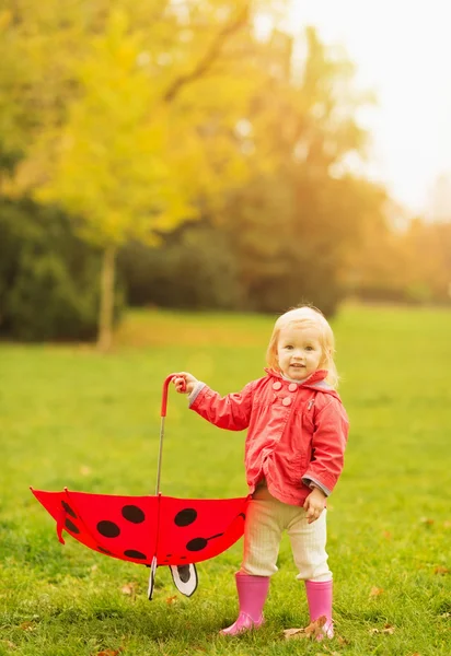 Mutlu bebek tutan kırmızı şemsiye — Stok fotoğraf